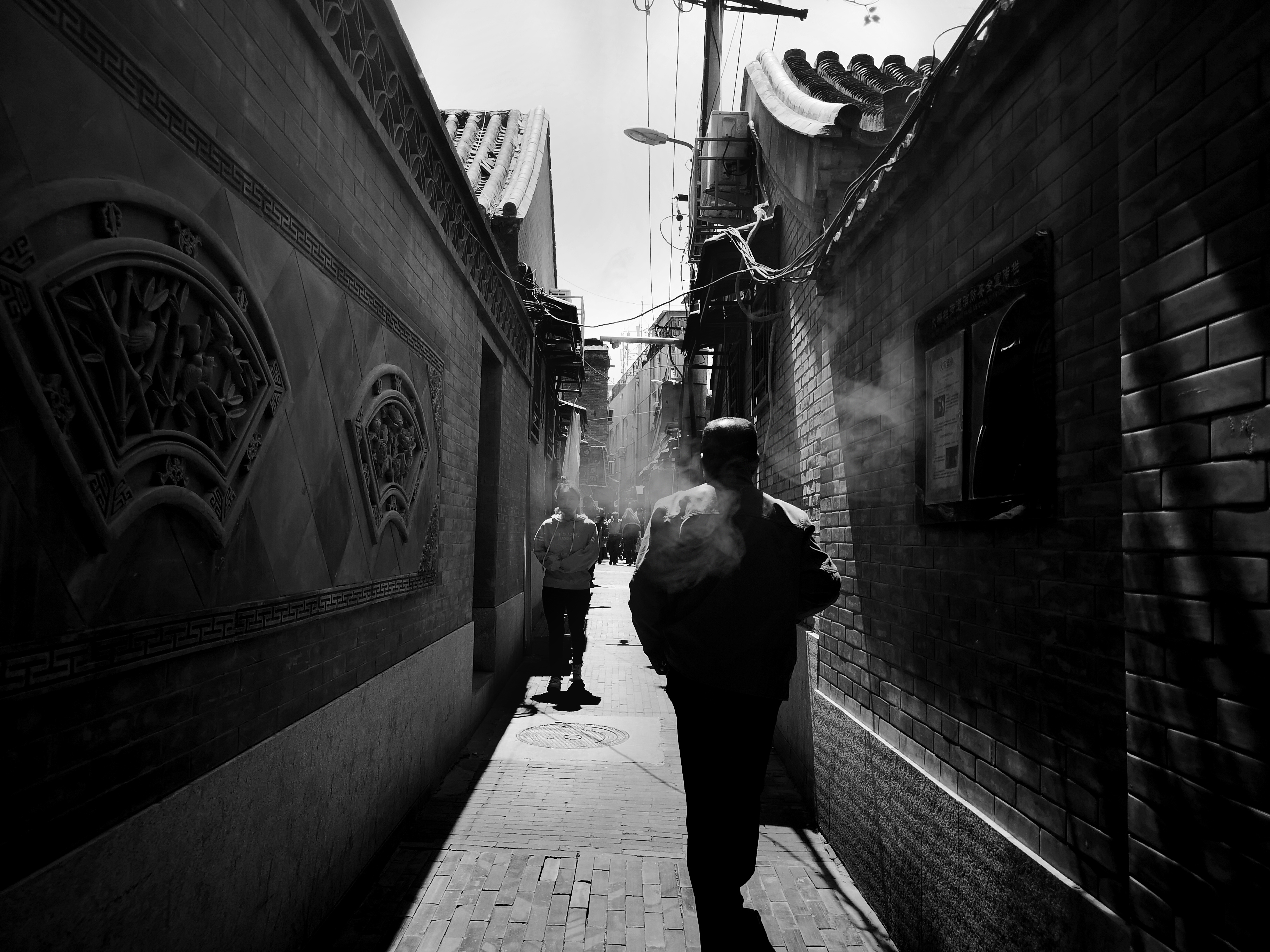 照片摄于北京胡同,一次偶然的抓拍,一位中年人疲惫的背影,匆匆走过这